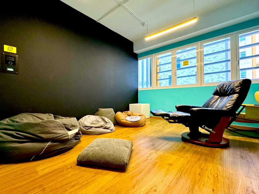 Quiet recovery room with bean bags, floor cushions and leather recliners beside a wall of windows