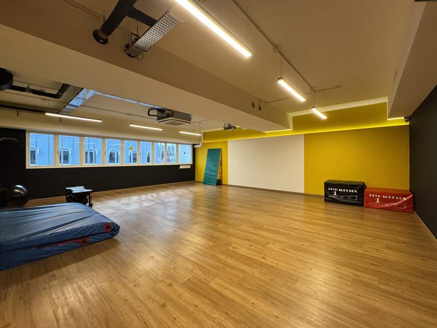 The empty GX studio showing the wooden floor, plyo soft boxes, crash mat and projector wall